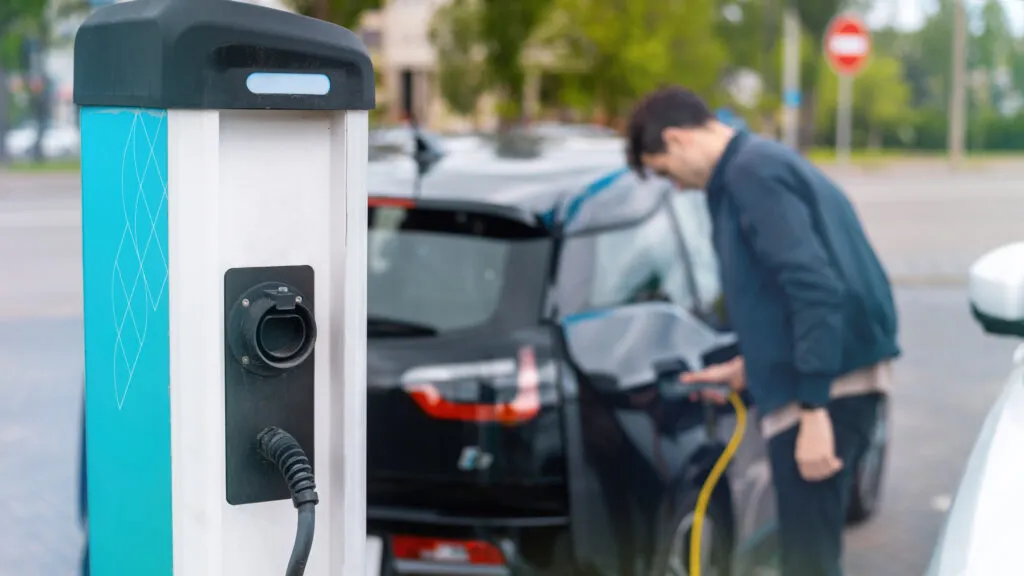 Un homme qui recharge sa voiture électrique