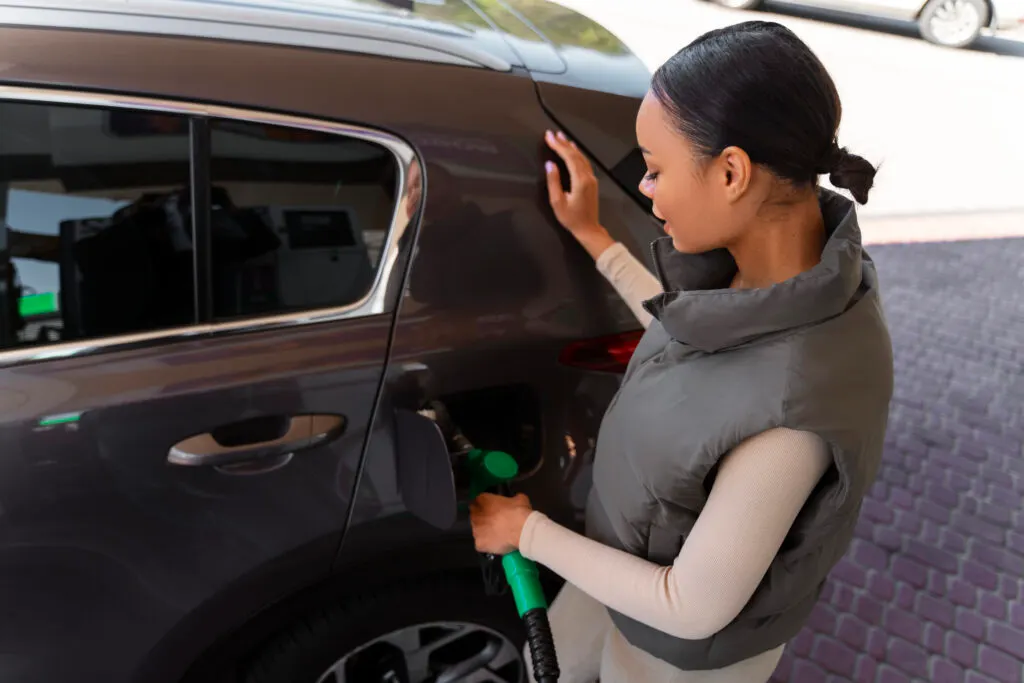 Une femme recharge sa voiture avec une ne borne et un câble de recharge
