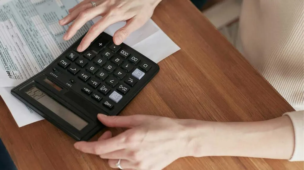 Quelqu'un calcule avec sa calculette pour faire les comptes