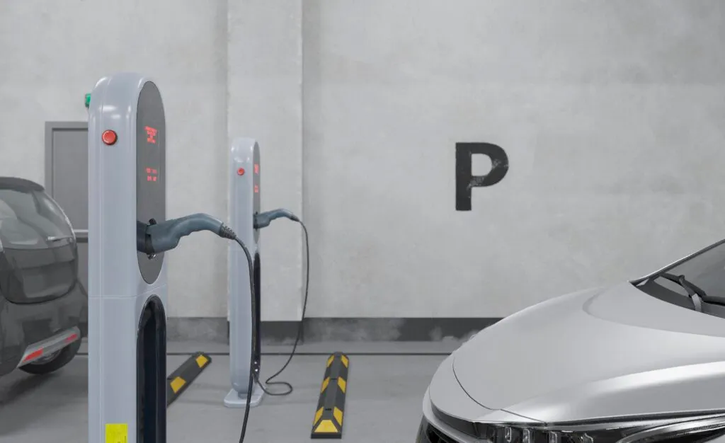 Une voiture qui recharge à une borne électrique dans un parking privé souterrain