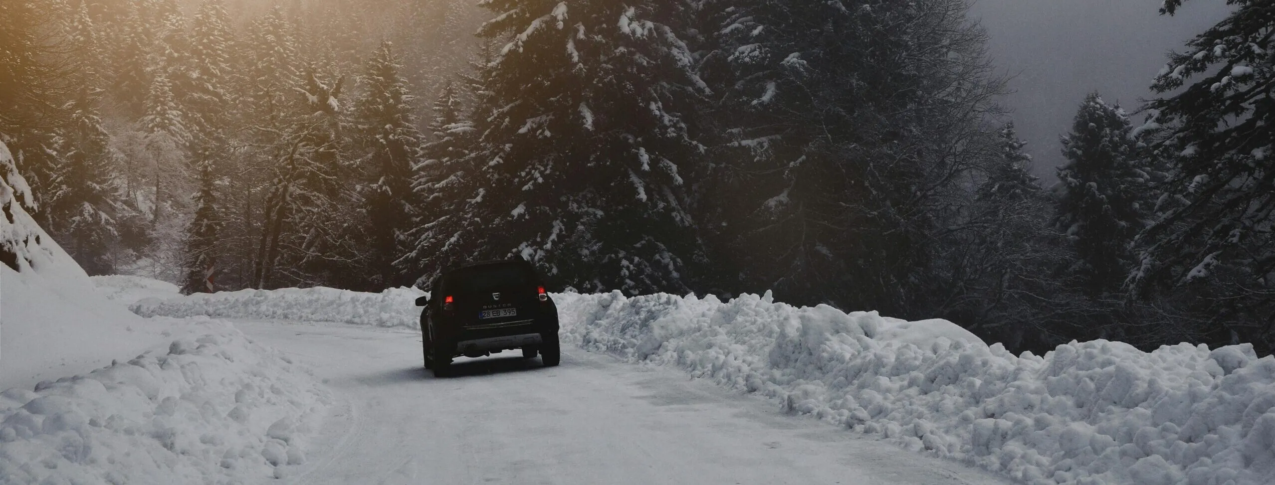 Une Dacia sur les routes enneigées pour l'article sur les accessoires de voiture pour l'hiver