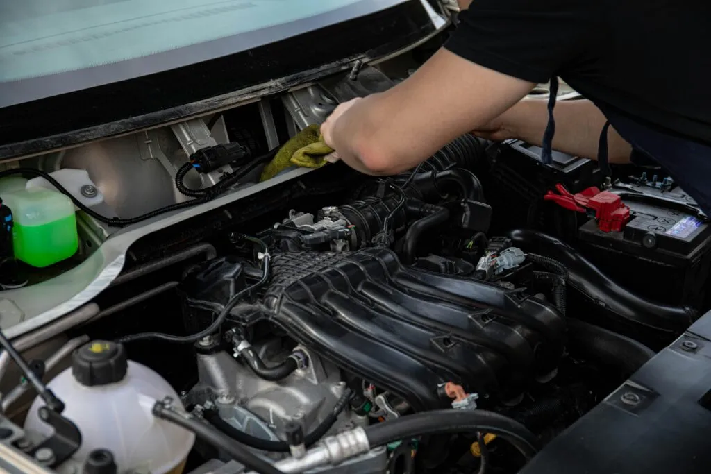 Un homme qui vérifie le moteur d'une voiture pour sa vidange