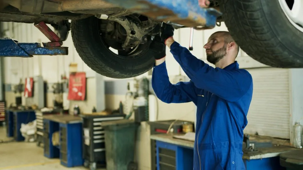 Homme qui nettoie une voiture dans un garage