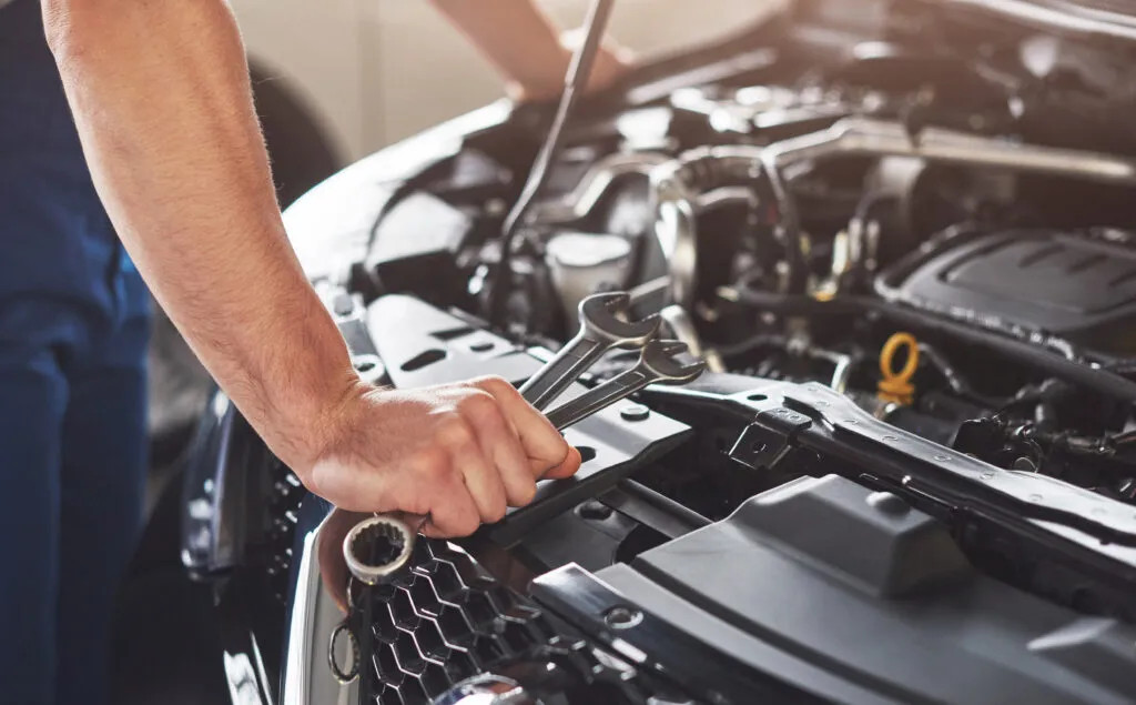 Mécanicien qui répare des éléments dans un moteur de voiture