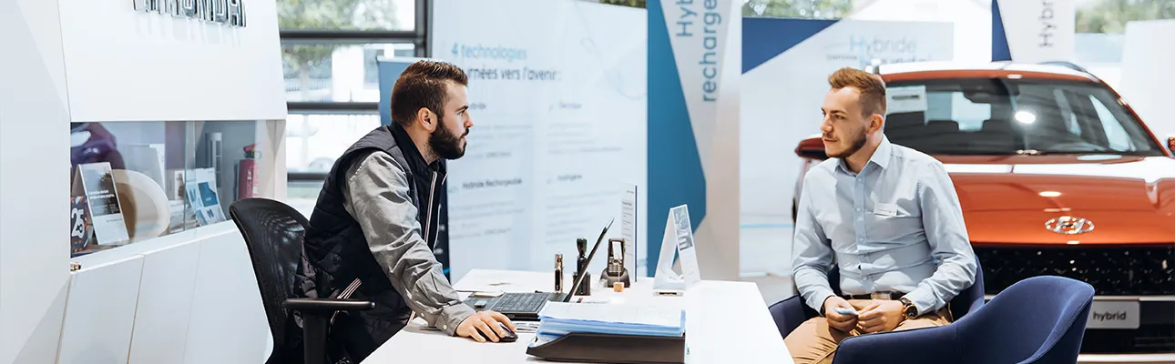 Un vendeur et un client dans un bureau dans une concession Hyundai