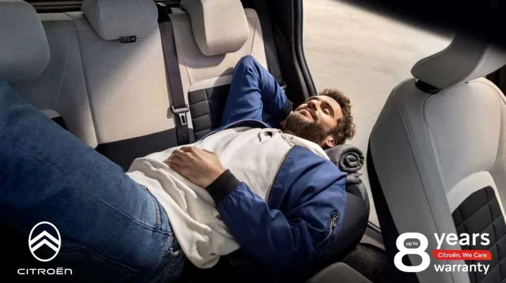 Un homme qui se repose dans une voiture parce que rassuré avec sa garantie