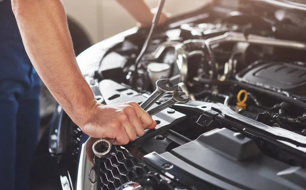 Mécanicien qui répare des éléments dans un moteur de voiture