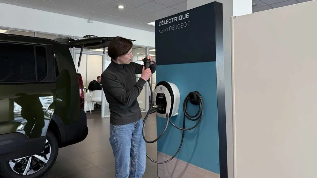 Une femme qui essaie de comprendre comment fonctionne la borne de recharge