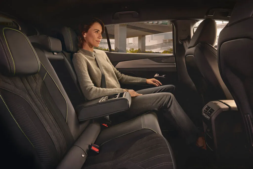 Une femme assise sur la banquete arrière dela Peugeot 408, profitant du confort