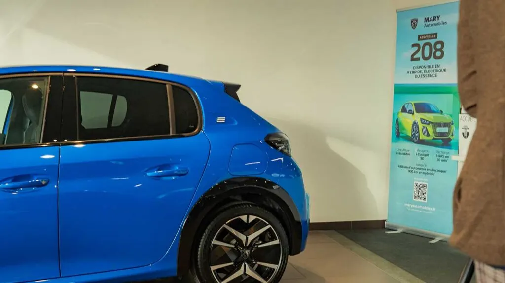 Une Peugeot e-208 dans une concession automobile