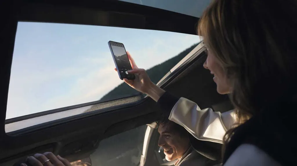 Une femme avec un portable à l'intérieur du Dacia Bigster