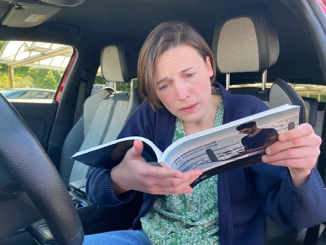 Une femme qui essaie de comprendre le livret de sa voiture