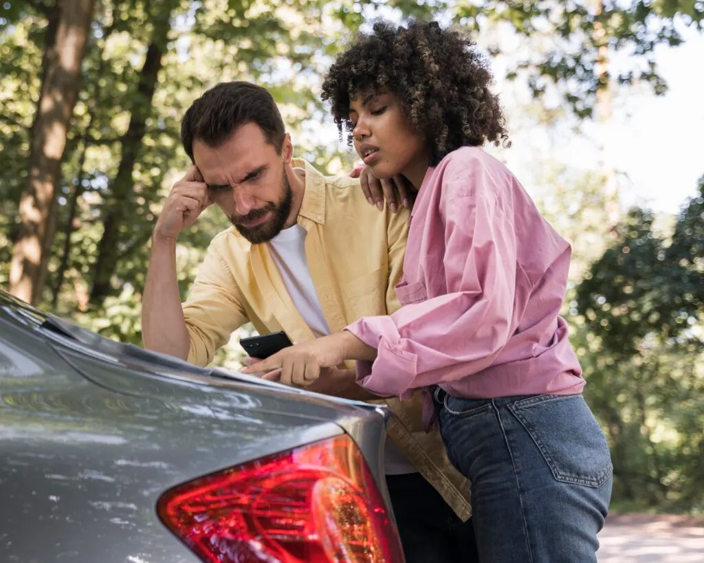 Un couple qui calcule et réfléchit aux meilleures solutions concernant l'achat de leur voiture