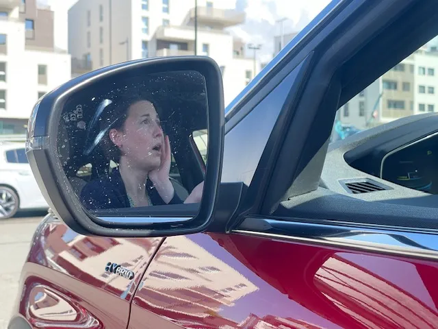 Femme paniquée devant des voyants voiture allumés qu'elle ne comprend pas