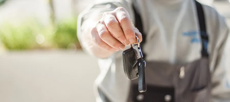 Entretien climatisation voiutre. Un concessionnaire rend les clés d'une voiture réparée au client