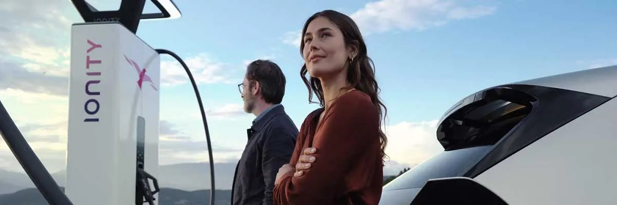 Des gens devant une voiture électrique qui sont rassurés avec leur garantie