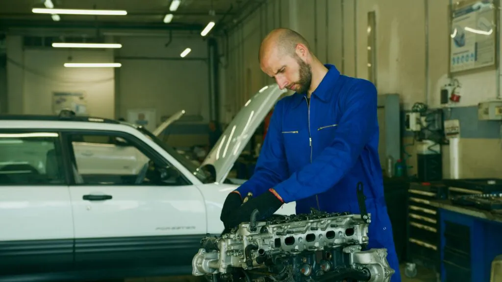 Un garagiste vérifie les pièces 'un moteur de voiture