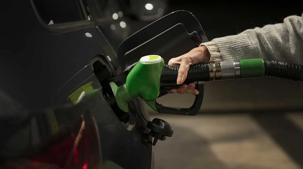 quelqu'un qui remplit sa voiture avec de l'essence à la pompe