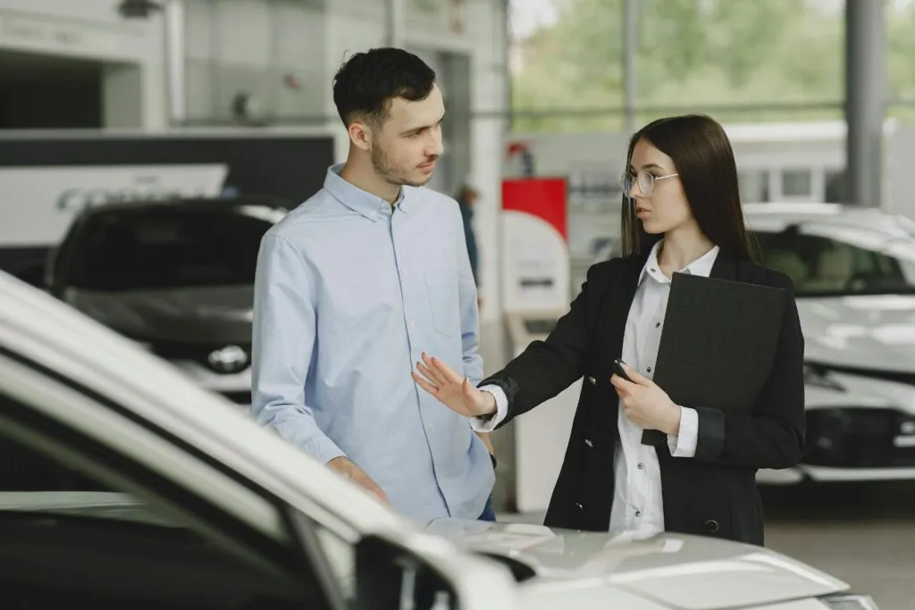 un couple qui cherche à vendre leur voiture d'occasion dans une concession