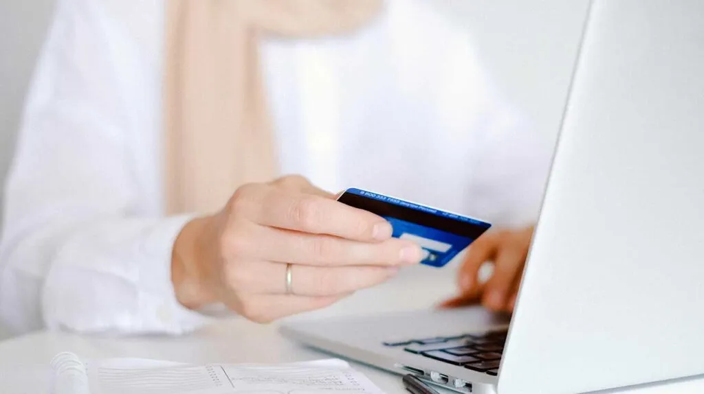 une femme avec une carte bancaire pour connaître ses économies