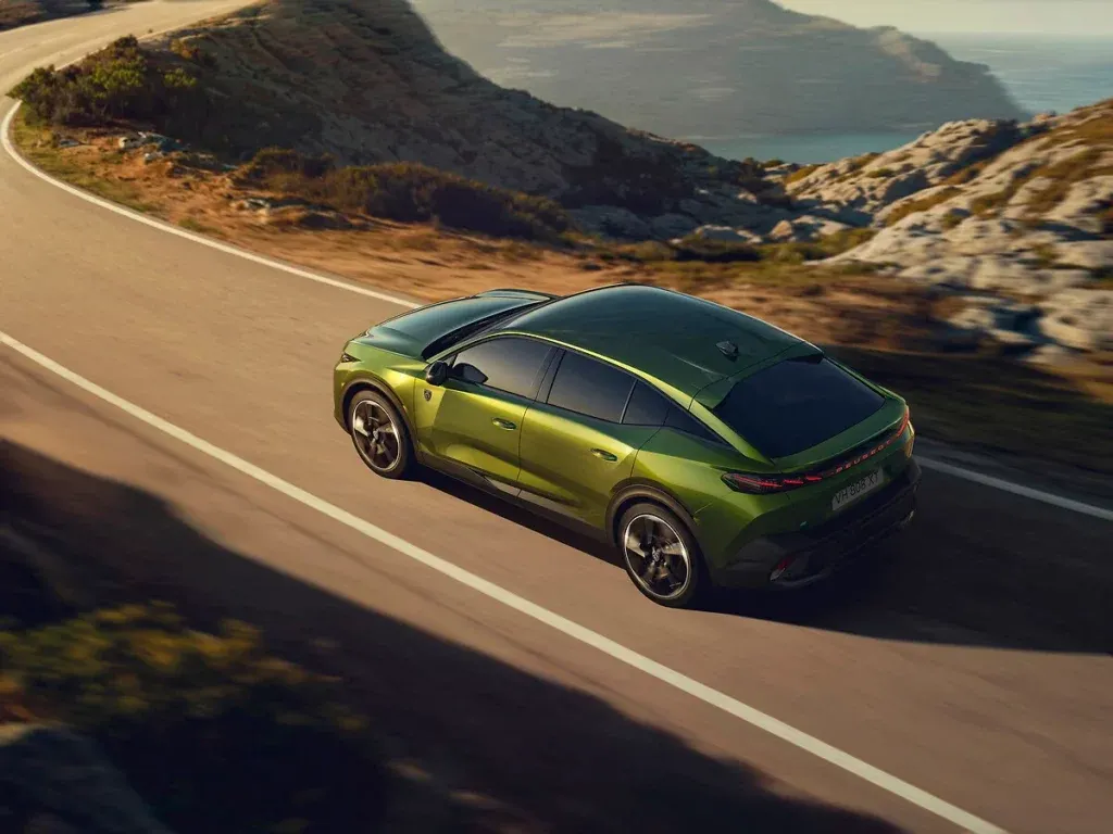 Nouvelle Peugeot 408  roulant avec un décor de falaise et de front de mer vue de haut